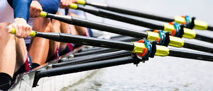 Close up of a men's quadruple skulls rowing team, seconds after the start of their race